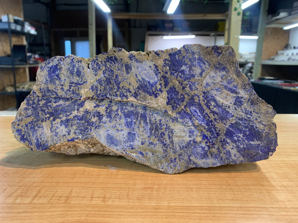 Natural lapis lazuli specimen with vivid blue mineralization in pale matrix
