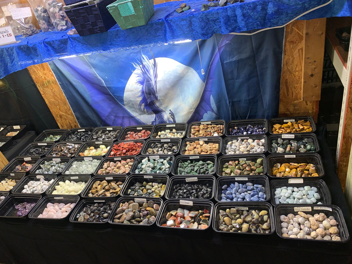 Assorted genuine tumbled crystals and polished mineral specimens in Earthforged's gemstone display.
