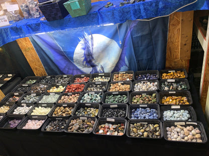 Assorted genuine tumbled crystals and polished mineral specimens in Earthforged's gemstone display.